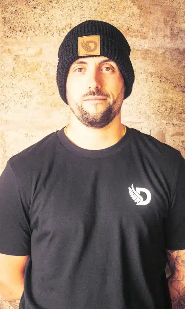 DROW Waffle Knit Beanie in black featuring a faux leather D patch Male Model