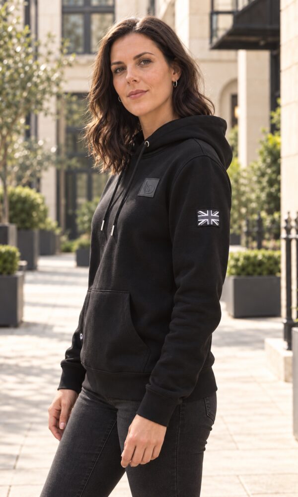 Woman wearing black DROW AJ Stealth Hoodie, side view showing Union Jack sleeve patch