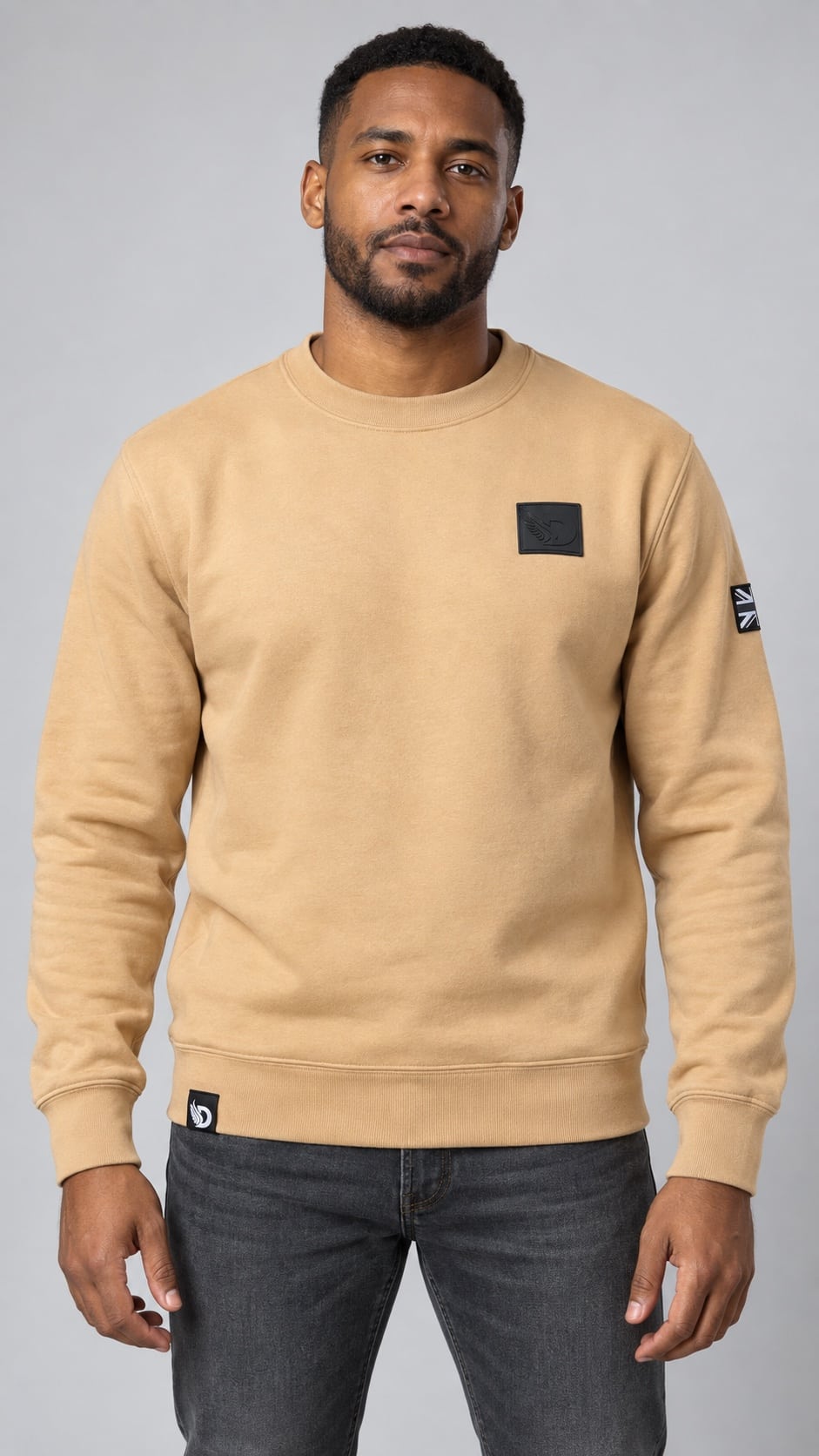 Male model wearing the Desert Stealth Sweatshirt, front view showing the chest patch, sleeve flag and hem tag