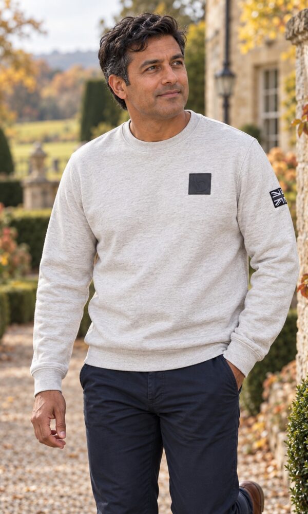 Man wearing the Moonstone Sweatshirt outdoors, front view showing chest patch and sleeve flag