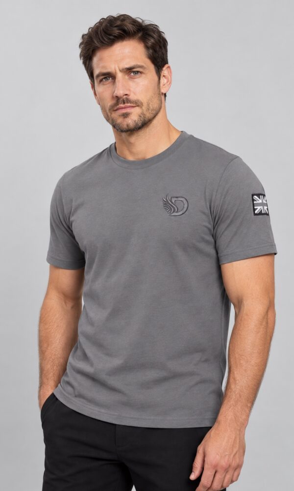 Male model wearing the DROW Graphite T-Shirt, front view showing tonal winged D embroidery and monochrome Union Jack sleeve patch