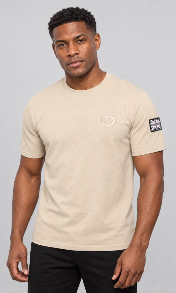 Male model wearing the DROW Khaki-Stone T-Shirt, front view showing tonal winged D embroidery and black and grey Union Jack sleeve patch