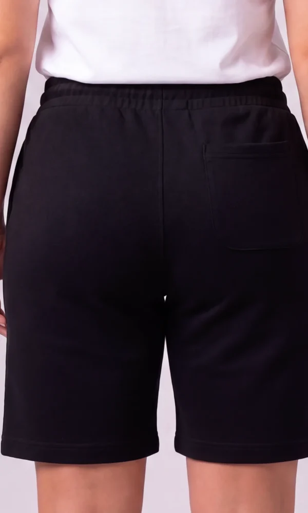 Back view of a woman wearing DROW Black Premium Shorts showing the elasticated waist and rear patch pocket