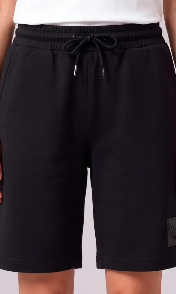 Front view of a woman wearing DROW Black Premium Shorts with a drawcord waist and tonal DROW leg patch