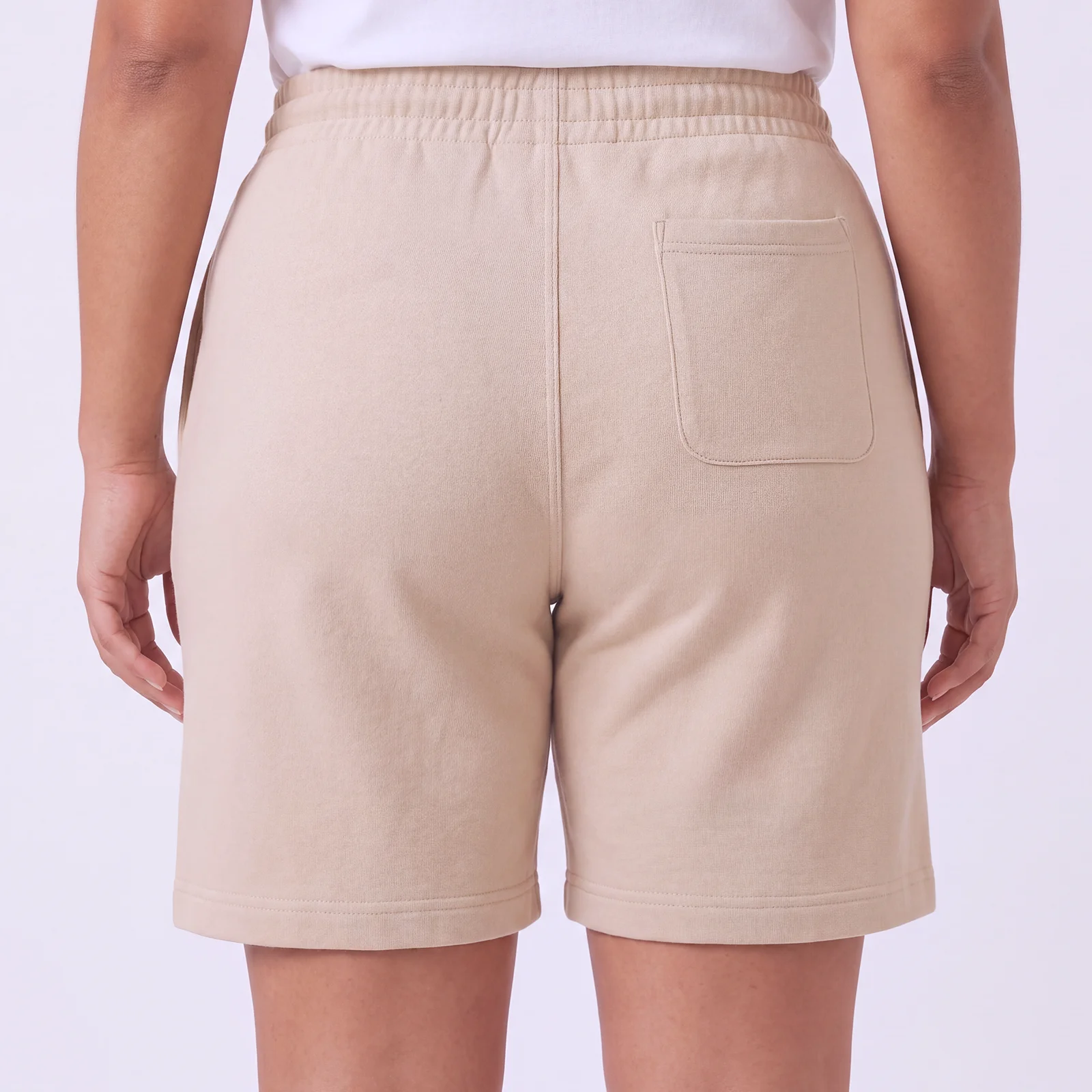 Back view of a woman wearing DROW Dust Premium Shorts showing the elasticated waist and rear patch pocket